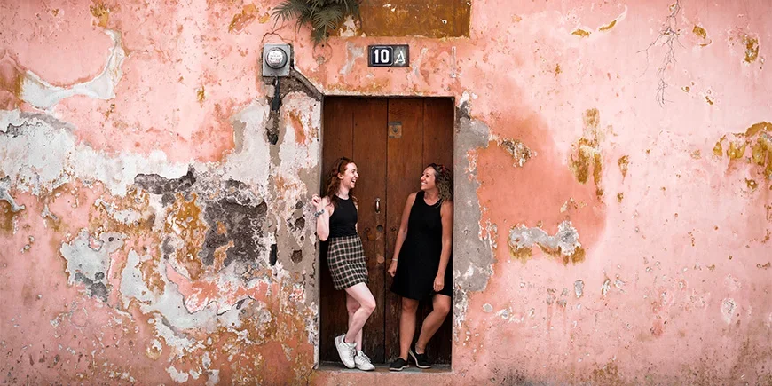 Zwei Frauen vor einer farbenfrohen Wand in Antigua, Guatemala