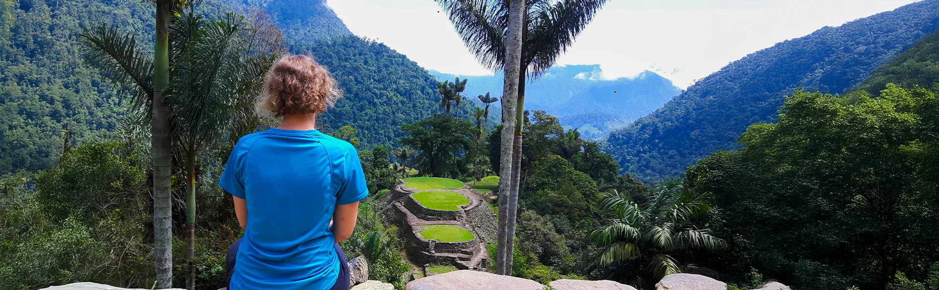 Eine Frau sitzt und blickt auf den atemberaubenden Lost City Trek in Kolumbien hinaus.