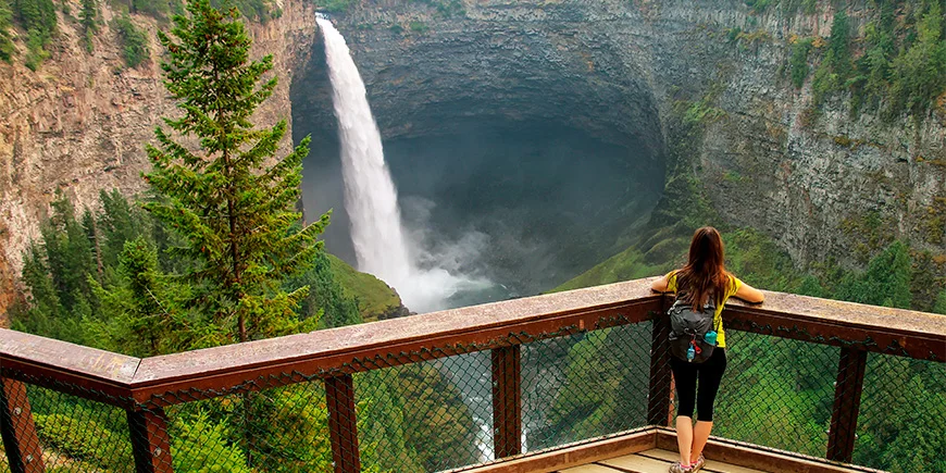 Frau betrachtet einen Wasserfall im Wells Grat Provincial Park