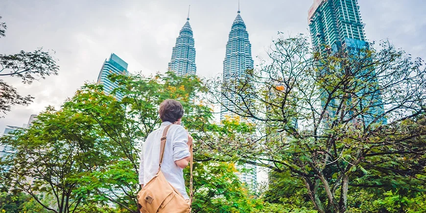 Mann blickt auf die Petronas Twin Towers in Kuala Lumpur, Malaysia