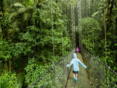 Kinder überqueren im Regen eine Hängebrücke in Costa Rica