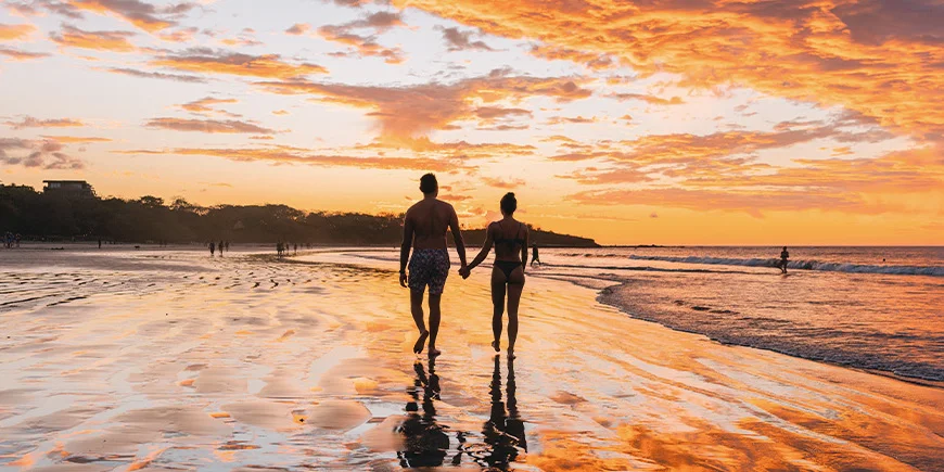 Mann und Frau spazieren am Tamarindo Beach in Costa Rica
