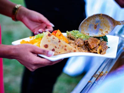 Frau hält einen Teller mit Essen in Kenia