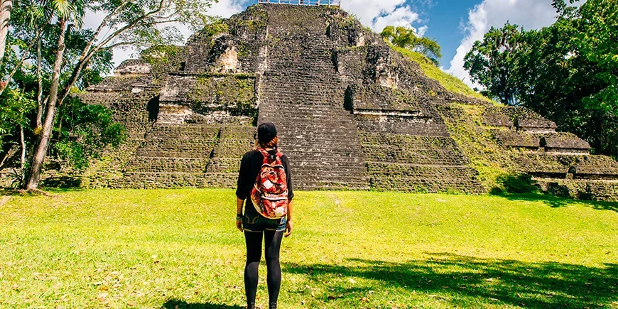 Frau vor einer Pyramide im Nationalpark Tikal