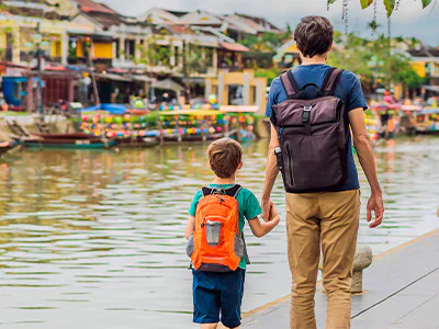 Vater und Sohn gehen Hand in Hand durch Hoi An