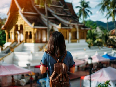 Eine Frau bewundert einen Tempel in Luang Prabang, Laos