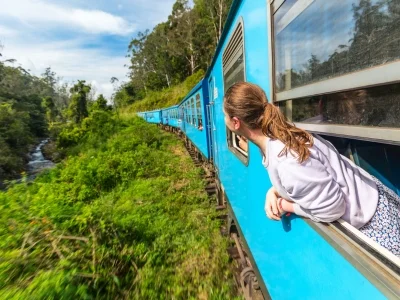 Frau blickt aus einem Zugfenster in Sri Lanka