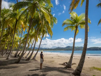 Eine Frau steht am Strand von Playa Sámara und blickt hinaus aufs Meer