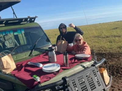 Zwei Personen frühstücken im Safarifahrzeug