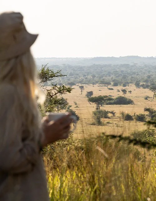 Frau blickt über die Savannenlandschaft