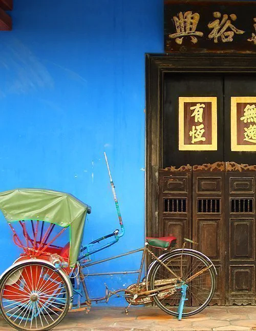 Blaue Haustür eines chinesischen Hauses mit Rikscha in Singapur